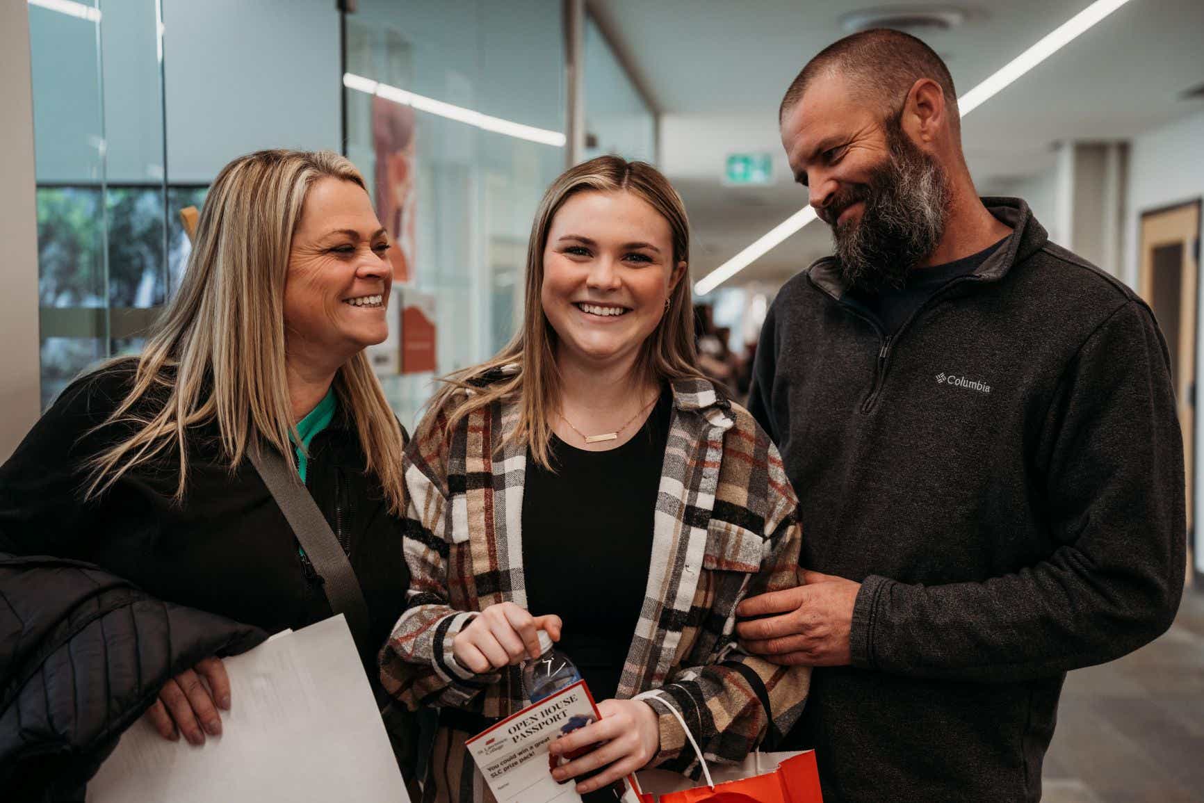 A family smiles while attending Open House in Kingston